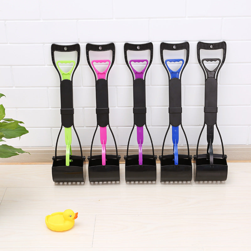 Five dog pooper scoops with colorful handles on a white floor.