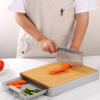 Person using a knife on a cutting board with vegetables on a kitchen counter